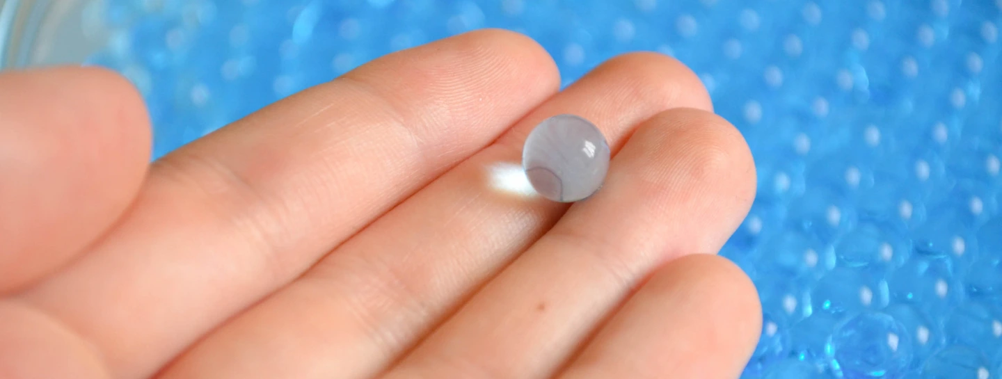 Hand holding Desiccant Bead up close Hand holding Desiccant Bead up close