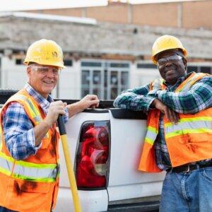 Workers leaning on tailgate of pickup truck
