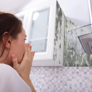 Person reacting in shock to mold growth in the home