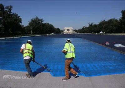 blue-protective-epoxy-coatings-spread-on-reflecting-pool-close-up-of-contractor-working-on-spreading-blue-protective-epoxy-coating-to-the-reflecting-pool-with-Lincoln-Memorial-in-background