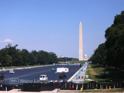 side angle view of reflecting pool with contractors working on waterproofing - card